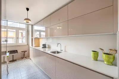 a kitchen with white cabinets and a sink at VIVA Aliados Spacious & Bright Flat in Porto
