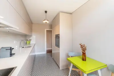 a kitchen with a yellow table and a counter at VIVA Aliados Spacious & Bright Flat in Porto