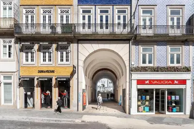 an archway in a building with people walking in the street at VIVA Aliados Spacious & Bright Flat in Porto