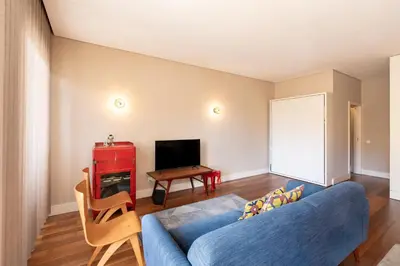 a living room with a blue couch and a table at VIVA Aliados Spacious & Bright Flat in Porto
