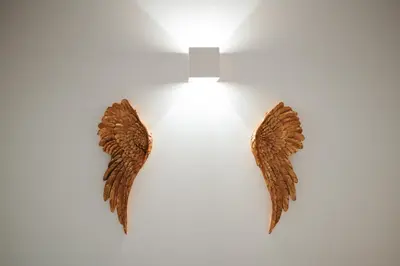 two brown angel wings on a white wall at Flores Street Apartments in Porto