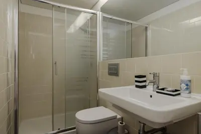 a bathroom with a toilet and a sink and a shower at Flores Street Apartments in Porto