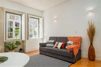 a living room with a couch and two windows at Flores Street Apartments in Porto