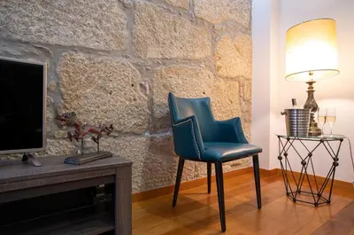 a blue chair in a living room with a tv at Authentic Porto Apartments in Porto