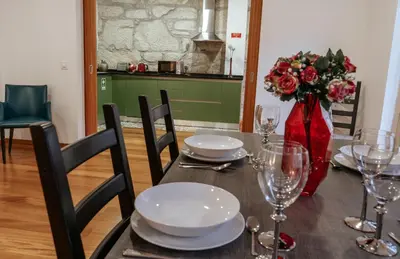 a dining room table with a vase of flowers and glasses at Authentic Porto Apartments in Porto