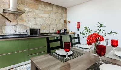 a kitchen with a table with red wine glasses at Authentic Porto Apartments in Porto