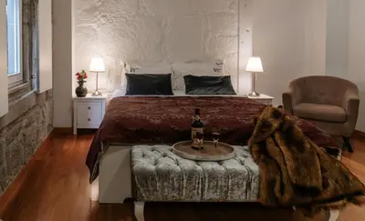 a bedroom with a bed and a table with a bottle of wine at Authentic Porto Apartments in Porto