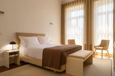a bedroom with a bed and a chair and a window at Oporto Comfort Charming Cedofeita - Free Parking in Porto