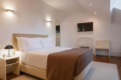 a bedroom with a bed and a tv on the wall at Oporto Comfort Charming Cedofeita - Free Parking in Porto