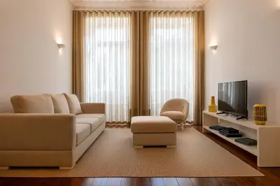 a living room with a couch and a tv at Oporto Comfort Charming Cedofeita - Free Parking in Porto