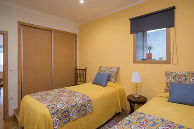a bedroom with two beds and a window at Casa do Cristelo in Porto