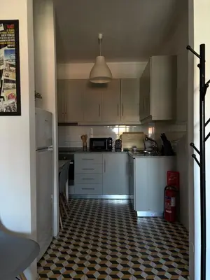 a kitchen with white cabinets and a checkered floor at Design Apartment Porto Downtown in Porto