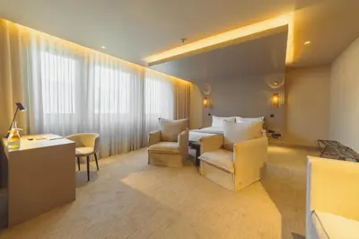 a hotel room with a bed and a desk and chairs at PortoBay Teatro in Porto