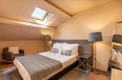 a bedroom with a bed and a chair at YOUROPO - Bolhao in Porto