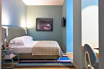 a bedroom with a bed and a desk with a computer at The Editory House Ribeira Porto Hotel in Porto