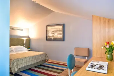 a bedroom with a bed and a table and a chair at The Editory House Ribeira Porto Hotel in Porto