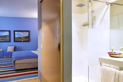 a bathroom with a shower and a bedroom with a bed at The Editory House Ribeira Porto Hotel in Porto