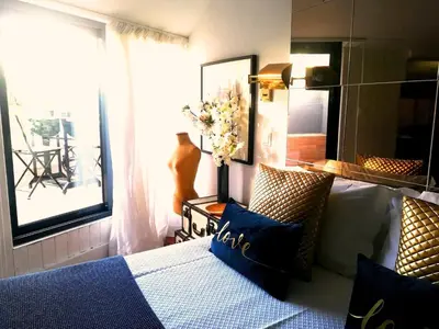 a bedroom with a bed and a table and windows at The Gallery Studios in Porto