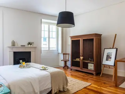 a white room with a bed and a cabinet at Down2Town B&B in Porto