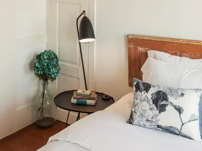 a bedroom with a bed and a table with a lamp at Down2Town B&B in Porto