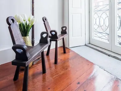 two chairs and a vase of flowers sitting in front of a door at Down2Town B&B in Porto