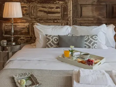 a tray of fruit on a white bed at Down2Town B&B in Porto