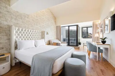 a bedroom with a large white bed and a desk at Eurostars Porto Douro in Porto