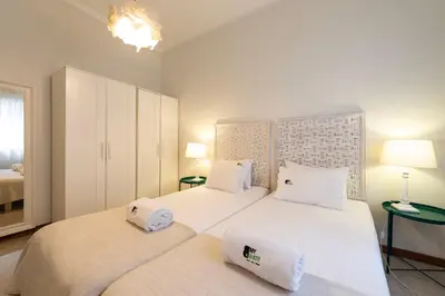 a bedroom with two beds with white sheets and pillows at BmyGuest - Santa Catarina Downtown Apartment in Porto