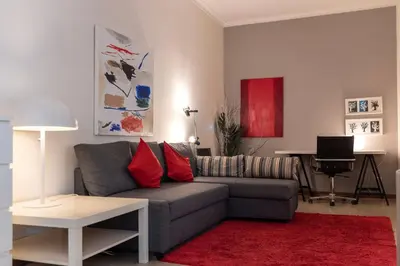 a living room with a gray couch and a red rug at BmyGuest - Santa Catarina Downtown Apartment in Porto