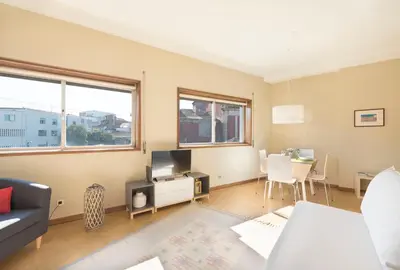 a living room with a couch and a tv at BmyGuest - Santa Catarina Light Apartment in Porto