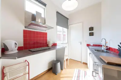 a kitchen with red tiles on the counters and a sink at BmyGuest - Santa Catarina Light Apartment in Porto