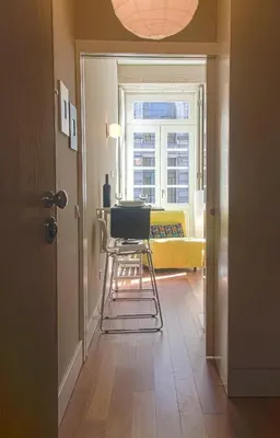a hallway with a table and a chair in a room at BmyGuest - Cardosas Stylish Apartment in Porto