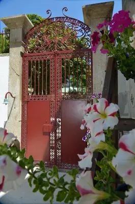 a red gate with flowers in front of it at Dukes Corner Guest House in Porto