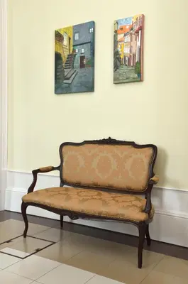 a bench in a room with paintings on the wall at Dukes Corner Guest House in Porto