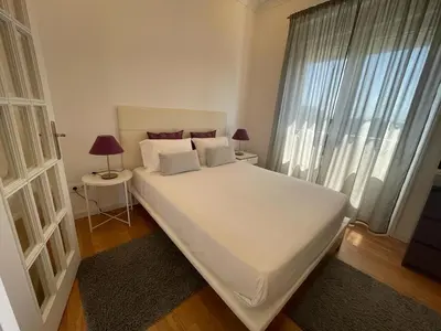 a large white bed in a room with a window at Burgães II Apartment in Porto