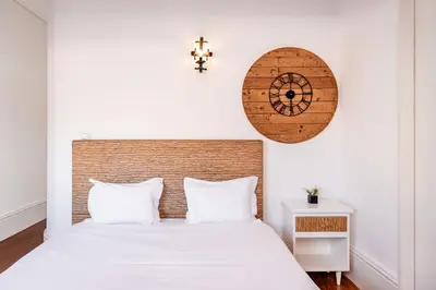 a bedroom with a bed and a clock on the wall at VIVA Almada Flats in Porto