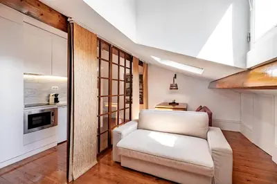 a living room with a white couch and a kitchen at VIVA Almada Flats in Porto
