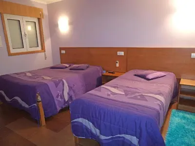 two beds in a hotel room with purple sheets at Monte Carlo Love Porto in Porto