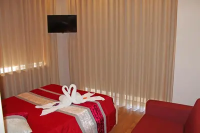 a room with a red bed with white bows on it at Monte Carlo Love Porto in Porto