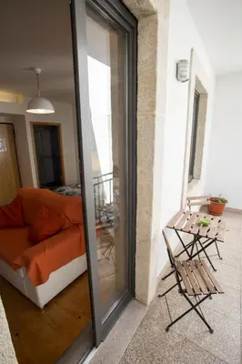 a living room with a couch and a sliding glass door at LivingPorto Apartments by Porto City Hosts in Porto