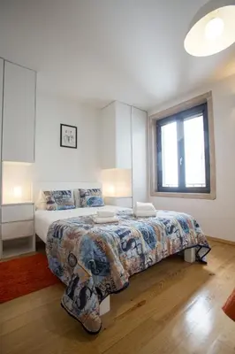 a bedroom with a large bed and a window at LivingPorto Apartments by Porto City Hosts in Porto