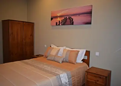 a bedroom with a bed and a painting on the wall at GuestHouse Belo Horizonte in Porto