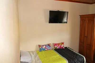 a bedroom with a bed with a television on the wall at Residencia Vale Formoso in Porto
