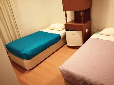 a small room with two beds and a night stand at Residencia Vale Formoso in Porto