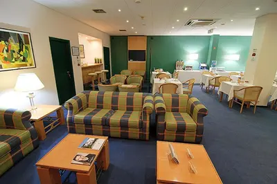 a waiting room with couches and tables and a dining room at Hotel Douro in Porto