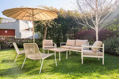 a group of chairs and a table with an umbrella at Oporto Maison Alves da Veiga in Porto