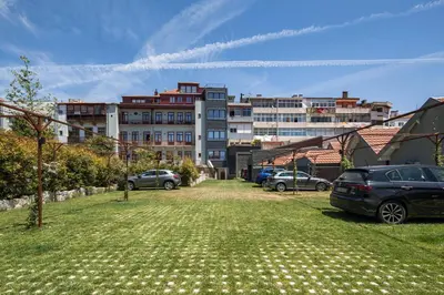 a parking lot with cars parked in front of a building at Oporto Maison Alves da Veiga in Porto