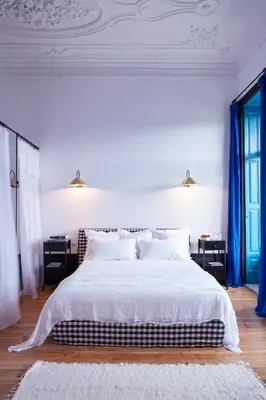 a bedroom with a large white bed with blue curtains at Cocorico Luxury House - Porto in Porto