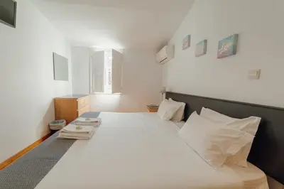 a bedroom with a large bed with white sheets and pillows at Dear Porto By Hosty in Porto