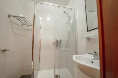 a white bathroom with a shower and a sink at Dear Porto By Hosty in Porto